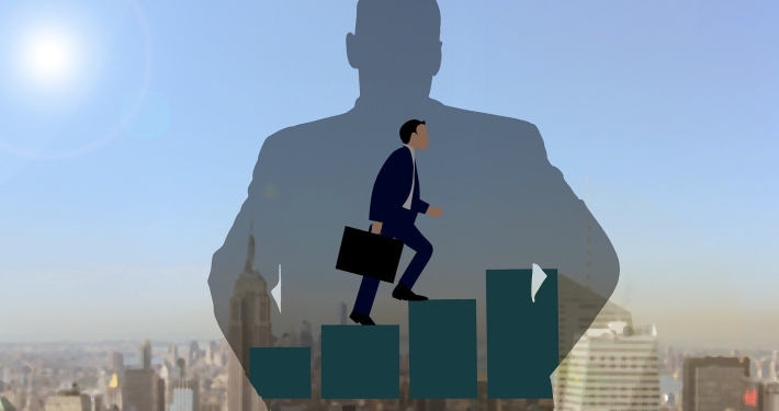 Foto-Collage: Grafik Business-Mensch steigt Treppe aus Statistikbalken hoch vor Hintergrund Großstadtfoto